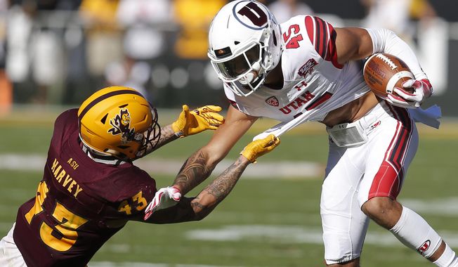 Arizona State safety Jalen Harvey (43) holds on for a tackle of Utah wide receiver Samson Nacua in the first half during an NCAA college football game, Saturday, Nov 3, 2018, in Tempe, Ariz. (AP Photo/Rick Scuteri)