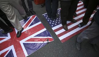Representations of the U.S. and British flags are walked on by demonstrators during an annual rally in front of the former U.S. Embassy in Tehran, Iran, on Sunday, Nov. 4, 2018, to mark the 39th anniversary of the seizure of the embassy by militant Iranian students. Thousands of Iranians rallied in Tehran on Sunday to mark the anniversary as Washington restored all sanctions lifted under the nuclear deal. (AP Photo/Vahid Salemi)