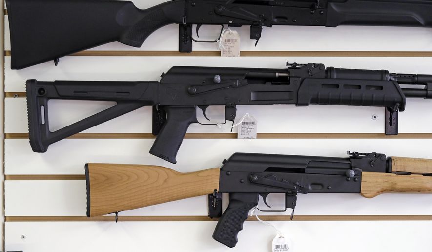 Semi-automatic rifles are displayed on a wall at a gun shop. (AP Photo/Elaine Thompson, File)