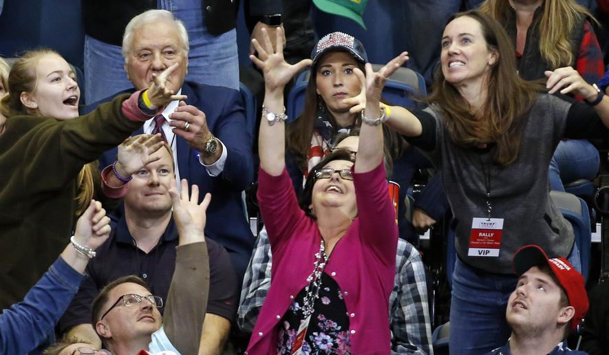 People reach for a cap thrown into the crowd before the start of a rally with President Donald Trump Sunday, Nov. 4, 2018, in Chattanooga, Tenn. (AP Photo/Mark Humphrey)