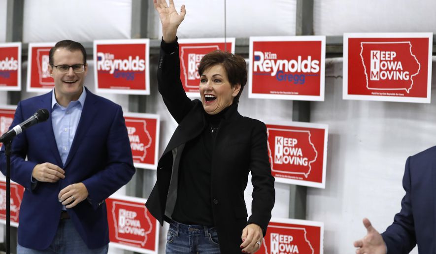 Iowa Gov. Kim Reynolds waves to supporters before speaking at a campaign rally, Monday, Nov. 5, 2018, in Ankeny, Iowa. Iowa acting Lt. Gov. Adam Gregg, left, looks on. (AP Photo/Charlie Neibergall)