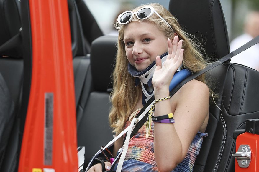 FILE - In this July 4, 2018 file photo, Ella Whistler serves as a grand marshal as she rides with her family in the Fourth of July Parade in Noblesville, Ind. Wistler survived a school shooting by a 13 year-old boy at Noblesville West Middle School in May. The boy admitted in court Monday, Nov. 5, 2018, to shooting and wounding a classmate and a teacher at the suburban Indianapolis school, saying in a statement read by his attorneys during a juvenile court hearing that, "If I could, I would take it back." (Jenna Watson/The Indianapolis Star via AP File)