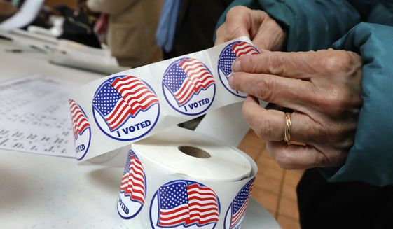 A voter retrieves her &quot;I Voted&quot; sticker after casting her ballot at the Presbyterian Church of Mount Kisco, in Mount Kisco, N.Y. Tuesday, Nov. 6, 2018. (AP Photo/Richard Drew) ** FILE **