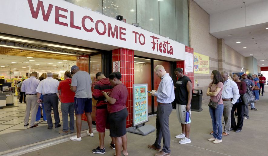 Voters line up outside of Fiesta Mart to vote on Election Day, Tuesday, Nov. 6, 2018, in Houston. (Yi-Chin Lee /Houston Chronicle via AP)