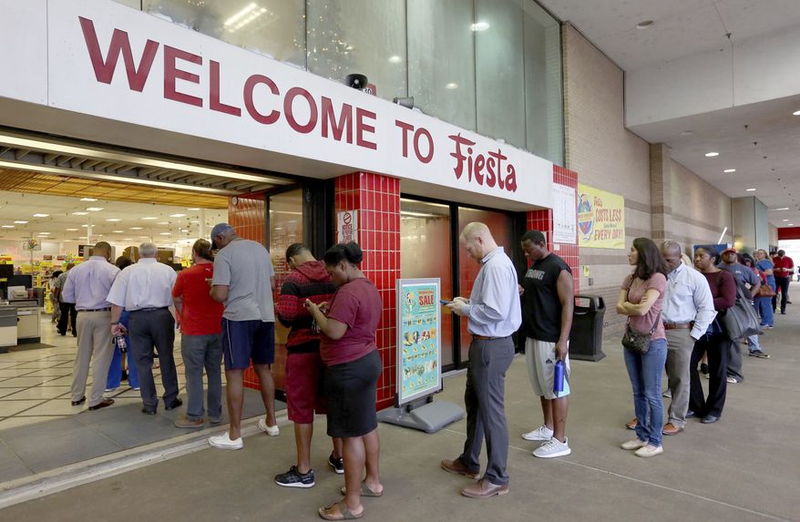 Voters line up outside of Fiesta Mart to vote on Election Day, Tuesday, Nov. 6, 2018, in Houston. (Yi-Chin Lee /Houston Chronicle via AP)