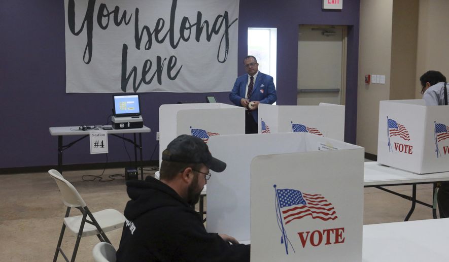 Assistant official of elections Edgar De Leon Izeppi, background, awaits completed ballots at Victory Restoration Church in Christiansburg, Va., Tuesday, Nov. 6 2018. (Matt Gentry/The Roanoke Times via AP)