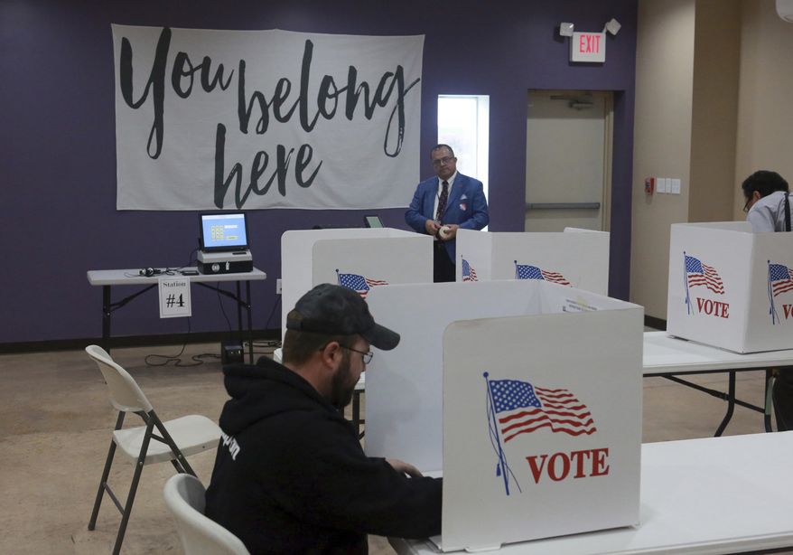 Assistant official of elections Edgar De Leon Izeppi, background, awaits completed ballots at Victory Restoration Church in Christiansburg, Va., Tuesday, Nov. 6 2018. (Matt Gentry/The Roanoke Times via AP)