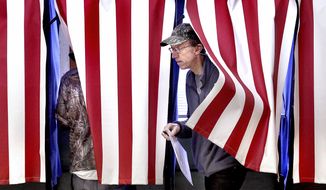 Dan Chase steps out of a voting booth Tuesday, Nov. 6, 2018, at Town of Hamilton Town Hall in West Salem, Wis. (Peter Thomson/La Crosse Tribune via AP)