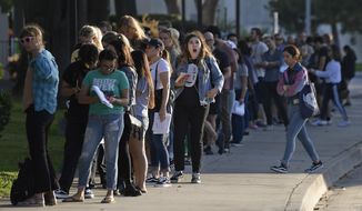 A woman yawns as she waits in a long line to register and vote at the Los Angeles County Registrar&#39;s office Tuesday, Nov. 6, 2018, in Los Angeles. A spokesman with the registrar&#39;s office says the line at its headquarters in Norwalk is wrapping around the building and that wait times were at about two hours Tuesday. (AP Photo/Mark J. Terrill)