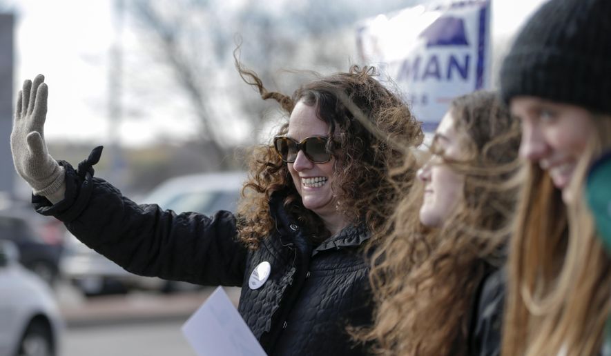 Democratic House candidate Kara Eastman waves to passing motorists in Omaha, Neb., Tuesday, Nov. 6, 2018. Eastman is challenging Nebraska&#x27;s 2nd District Rep. Don Bacon, R-Neb. (AP Photo/Nati Harnik)