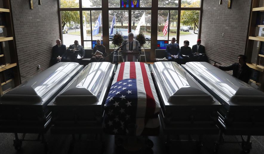The Rev. Dr. Louis Prues, of the Jefferson Ave. Presbyterian Church, reads some of the names of about 300 cremated remains recovered from a closed Detroit funeral home during an All Souls' Day Memorial Service, Friday, Nov. 2, 2018, at the Mount Olivet Cemetery in Detroit. More than 50 were read as "unidentified loved" ones. Placed in five coffins, the remains will be interred at the cemetery. They were found earlier this year at Cantrell Funeral Home which was shut down in April due to improperly stored bodies and other violations. (AP Photo/Carlos Osorio)