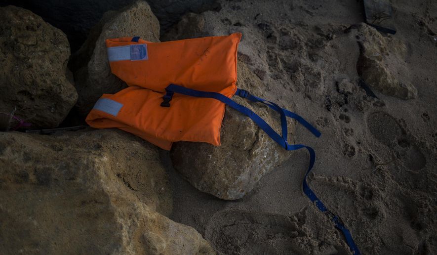 A life vest lies on the rocks near the village of Canos de Meca in southern Spain, Tuesday, Nov. 6 2018. Spain's maritime rescue service says at least 17 people have died trying to reach Spanish territory in boats departing from North Africa but rescued 80 people Monday from two boats and recovered the bodies of 13 dead migrants in the Alboran Sea, part of the western Mediterranean route into Europe. In a separate incident, the Spanish Civil Guard says it found four bodies of migrants and 22 survivors, all men from northern Africa, after their wooden dinghy hit a reef. (AP Photo/Javier Fergo)