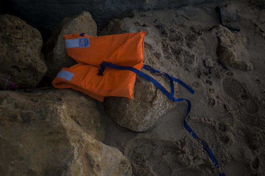 A life vest lies on the rocks near the village of Canos de Meca in southern Spain, Tuesday, Nov. 6 2018. Spain's maritime rescue service says at least 17 people have died trying to reach Spanish territory in boats departing from North Africa but rescued 80 people Monday from two boats and recovered the bodies of 13 dead migrants in the Alboran Sea, part of the western Mediterranean route into Europe. In a separate incident, the Spanish Civil Guard says it found four bodies of migrants and 22 survivors, all men from northern Africa, after their wooden dinghy hit a reef. (AP Photo/Javier Fergo)