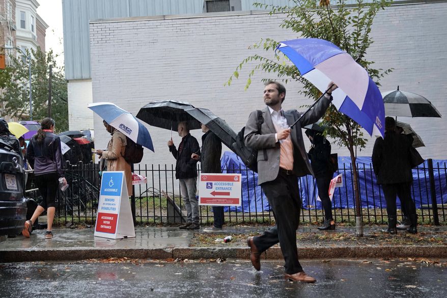 Voters line up in the rain outside Bright Family and Youth Center in the Columbia Heights neighborhood in Washington, Tuesday, Nov. 6, 2018. Across the country, voters headed to the polls Tuesday in one of the most high-profile midterm elections in years. (AP Photo/Pablo Martinez Monsivais) **FILE**