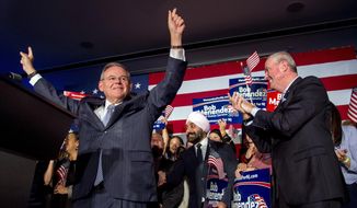 U.S. Sen. Bob Menendez celebrates his re-election in Hoboken, N.J., Tuesday, Nov. 6, 2018, while Gov. Phil Murphy stands at right. (Tom Gralish/The Philadelphia Inquirer via AP)