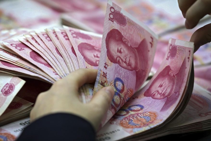 FILE - In this Nov. 25, 2016, file photo, a clerk counts Chinese currency notes at a bank outlet in Huaibei in central China's Anhui province. China's foreign currency reserves declined in October, 2018, suggesting Beijing might be intervening in market to keep its yuan's politically sensitive exchange rate from falling to far against the dollar. Central bank data on Wednesday, Nov. 7, 2018, showed the reserves, the world’s biggest, contracted by about $34 billion to just over $3 trillion.(Chinatopix via AP, File)