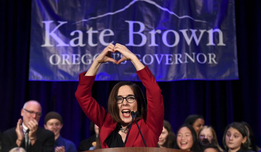 Gov. Kate Brown makes a heart-shape with her hands as she addresses the crowd after winning re-election in Portland, Ore., Tuesday, Nov. 6, 2018. (AP Photo/Steve Dykes)