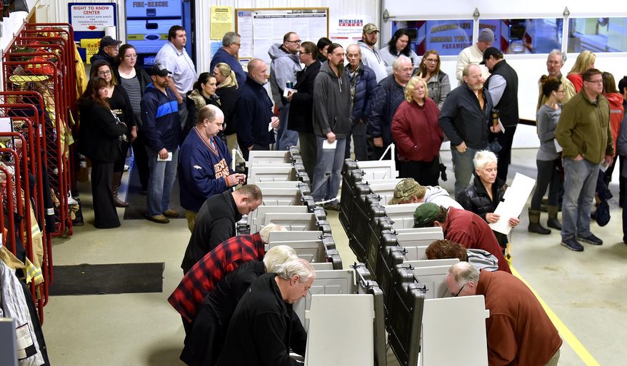 Voters wait on line to vote inside the fire bay at the Armada Twp. Fire Department, Tuesday , Nov.  6, 2018, in Armada Twp, Mich.  (Todd McInturf /Detroit News via AP)