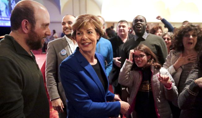 Wisconsin Democratic Sen. Tammy Baldwin and supporters react to early favorable results from the Wisconsin governors race on the large screen televisions at an election night party Tuesday Nov. 6, 2018, in Madison, Wis. Baldwin won in her re-election bid against Republican Leah Vukmir. (Steve Apps/Wisconsin State Journal via AP)