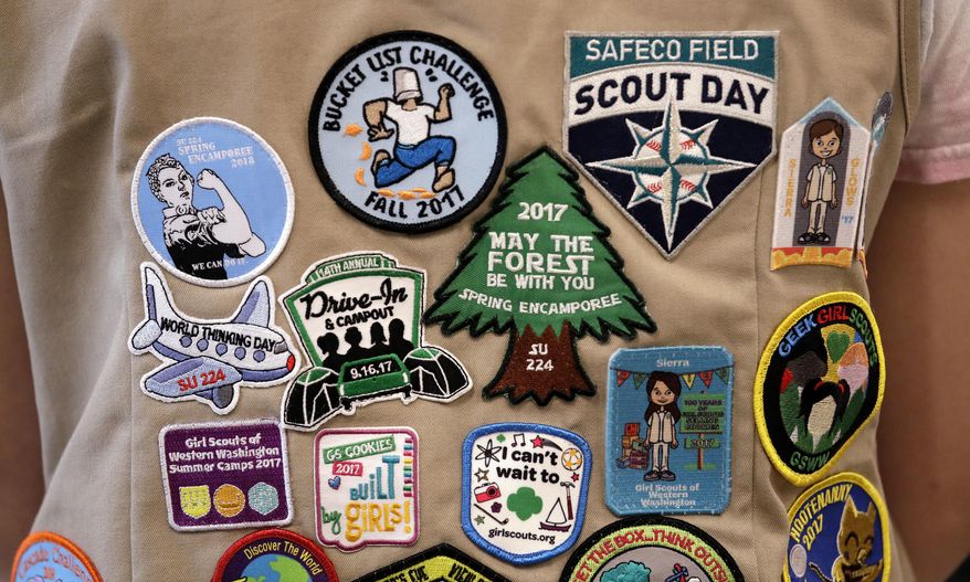 In this June 18, 2018, file photo, patches cover the back of a Girl Scout's vest at a demonstration of some of their activities in Seattle. The Girl Scouts of the United States of America filed a trademark infringement lawsuit on Monday, Nov. 5, against the Boy Scouts of America for dropping the word "boy" from its flagship program in an effort to attract girls. (AP Photo/Elaine Thompson) **FILE**
