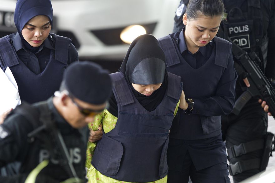 Indonesian Siti Aisyah is escorted by police as she arrives for a court hearing at Shah Alam High Court in Shah Alam, Malaysia, Wednesday, Nov. 7, 2018. The two woman arrived at court for case management after Malaysian court has ordered them to enter their defense over the murder of north Korean leader's half brother in an assassination that has gripped the world. (AP Photo/Yam G-Jun)