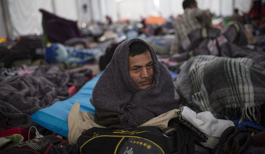 Alcides Padilla, from Honduras, wakes up at the Jesus Martinez stadium in Mexico City, Wednesday, Nov. 7, 2018. Central American migrants on Wednesday continued to straggle in for a rest stop at a Mexico City stadium, where about 4,500 continue to weigh offers to stay in Mexico against the desire of many to reach the U.S. border. (AP Photo/Rodrigo Abd)