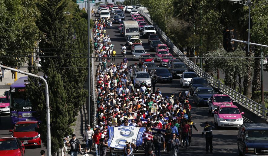 A group of Central American migrants, representing the thousands participating in a caravan trying to reach the U.S. border, undertake an hours-long march to the office of the United Nations&#39; humans rights body in Mexico City, Thursday, Nov. 8, 2018. Members of the caravan which has stopped in Mexico City demanded buses Thursday to take them to the U.S. border, saying it is too cold and dangerous to continue walking and hitchhiking.(AP Photo/Rebecca Blackwell)