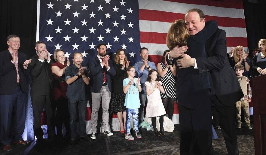 FILE - In this Tuesday, Nov. 6, 2018 file photo, Colorado Governor-elect Jared Polis hugs his Lt. Governor-elect Dianne Primavera during his victory speech at the watch party for Colorado Democrats at a hotel in downtown Denver. Polis became the first openly gay man elected as a governor of any state. (Jerilee Bennett/The Gazette via AP)