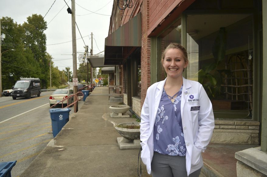 In this Oct. 18, 2018 photo, Bailey Flamm, a student at the Southern Illinois University School of Medicine, stands in her hometown of downtown Cobden, Ill. Long before she knew she wanted to go to medical school, Bailey Flamm knew that Southern Illinois didn't have enough doctors. Now a second-year student at the School of Medicine, Flamm is mostly focused on keeping up with a flood of homework and exams. But she is also preparing to make decisions that will shape her career: choosing a specialty, a residency site and eventually a place to call home. Gabe Neely-Streit, (Gabe Neely-Streit/The Southern, via AP)