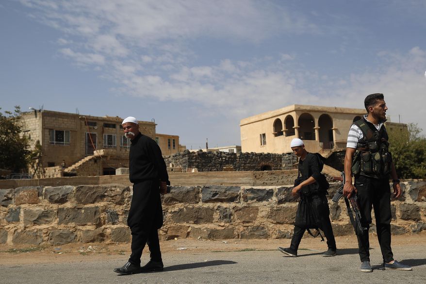 In this Thursday, Oct. 4, 2018, file photo, young Druze armed men, who carry weapons to defend their village from Islamic State attack, patrol the village of Rami in the southern province of Sweida, Syria. (AP Photo/Hassan Ammar, File)