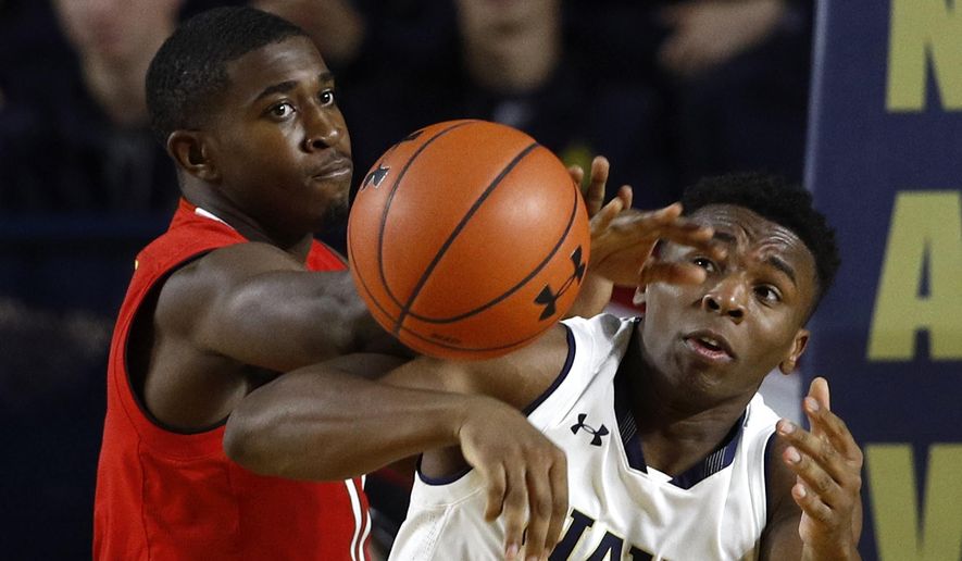 Maryland guard Darryl Morsell, left, and Navy guard Hasan Abdullah chase after a rebound in the first half of an NCAA college basketball game at the Veterans Classic tournament in Annapolis, Md., Friday, Nov. 9, 2018. (AP Photo/Patrick Semansky)