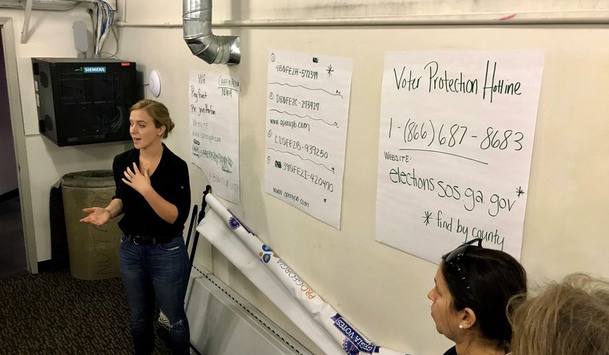 Helen Brosnan, of the National Domestic Workers Alliance, trains volunteers who are working the phones in a warehouse, Friday, Nov. 9, 2018, in Atlanta, where they are frantically trying to reach Georgians who voted with provisional ballots to make sure their votes are counted. (AP Photo/Jeff Martin)