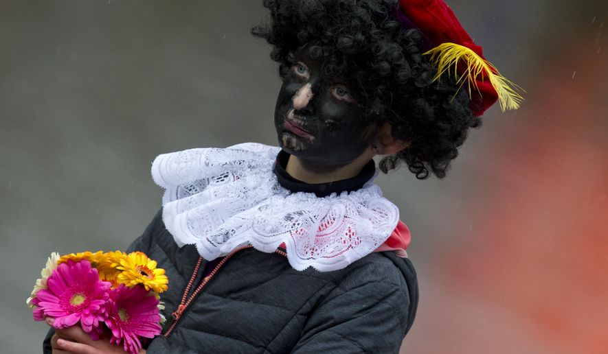 In this Saturday, Nov. 18, 2017, file photo, a child dressed as Black Pete waits for the arrival of Sinterklaas, in Dokkum, northern Netherlands. A court in the Netherlands has convicted 34 people on Friday NOv. 9, 2018, who blocked a highway last year to prevent anti-racism demonstrators reaching the nationally televised arrival of Sinterklaas, the Dutch version of Santa Claus, and his helpers called "Zwarte Piet", or Black Petes. Black Pete is often played by white people with their faces daubed in dark makeup. (AP Photo/Peter Dejong)