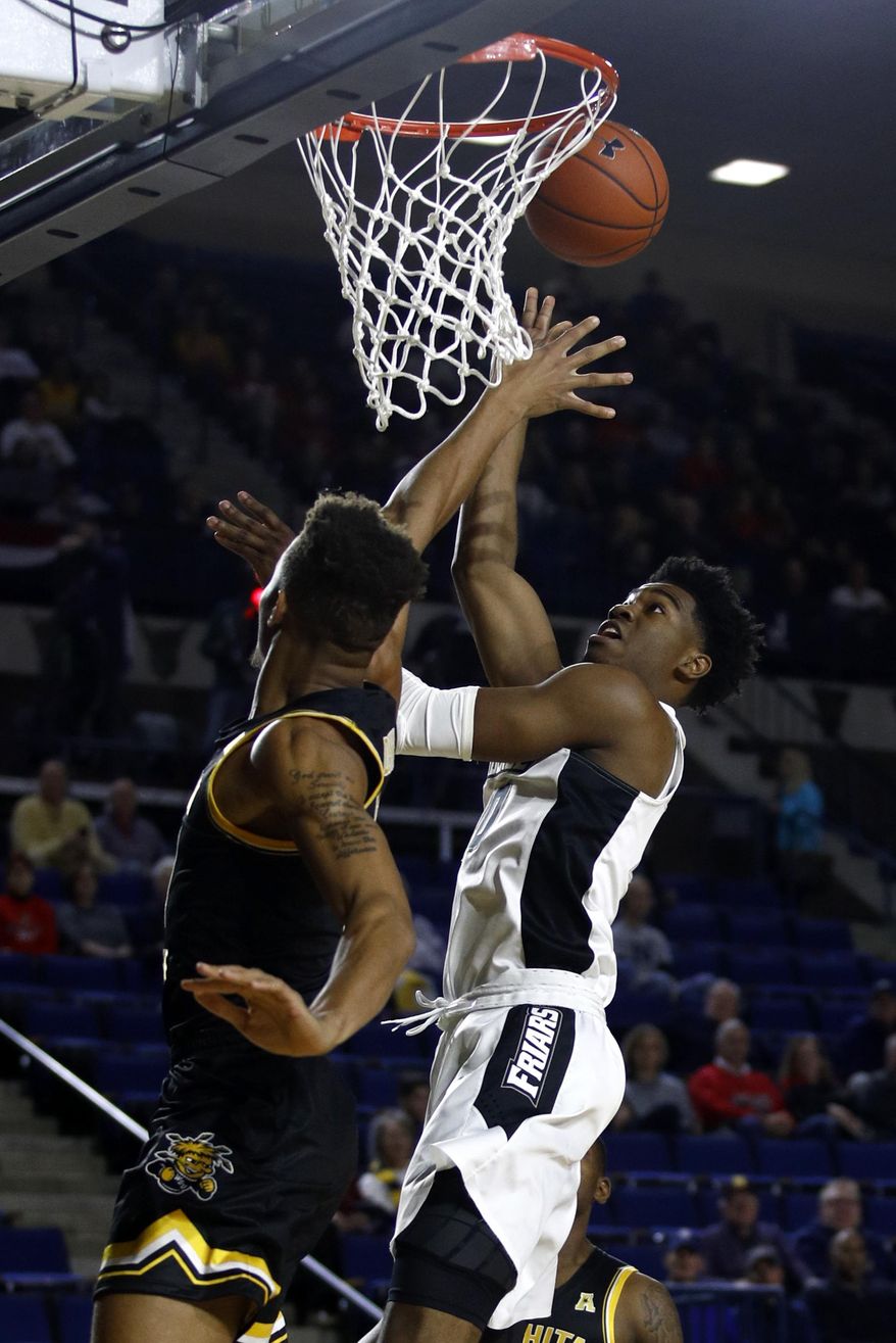 Providence guard A.J. Reeves, right, shoots over Wichita State guard Dexter Dennis in the first half of an NCAA college basketball game at the Veterans Classic tournament in Annapolis, Md., Friday, Nov. 9, 2018. (AP Photo/Patrick Semansky)
