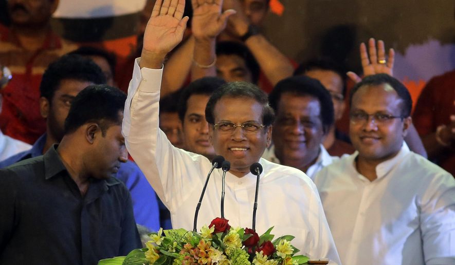 FILE - In this Nov. 5, 2018, file photo, Sri Lankan President Maithripala Sirisena, center, waves to supporters during a rally outside the parliamentary complex in Colombo, Sri Lanka. Sirisena on Friday, Nov. 9, 2018 dissolved Parliament and called for fresh elections amid a deepening political crisis. (AP Photo/Eranga Jayawardena, File)