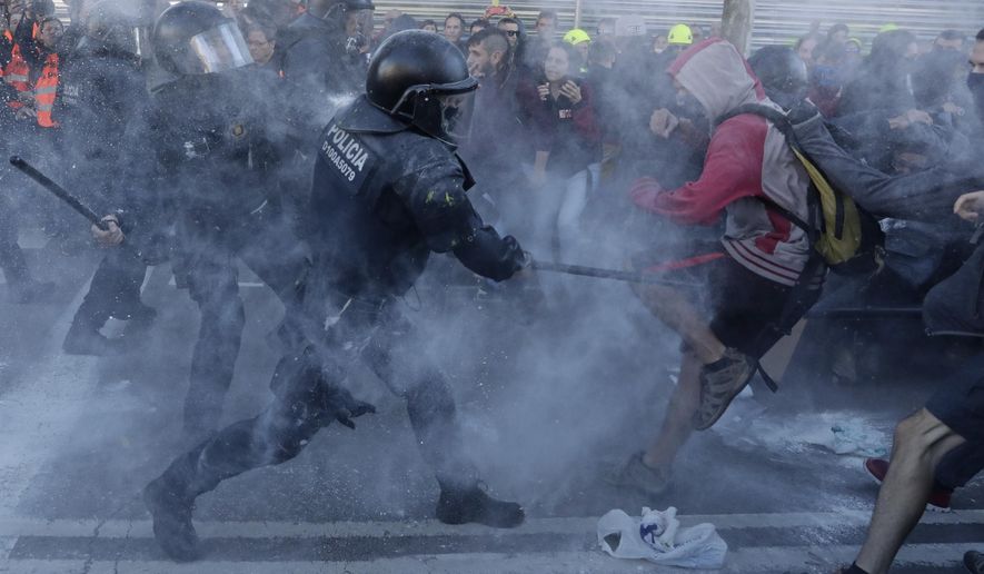 Police charge against protesters during a demonstration by CDR (Committees for the Defense of the Republic) in Barcelona, Spain, Saturday, Nov. 10, 2018. The so called Committees for the Defense of the Republic is a grassroots group that organise protests in Catalonia to press for their demand for independence. (AP Photo/Manu Fernandez)