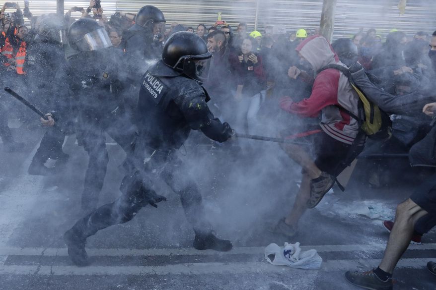 Police charge against protesters during a demonstration by CDR (Committees for the Defense of the Republic) in Barcelona, Spain, Saturday, Nov. 10, 2018. The so called Committees for the Defense of the Republic is a grassroots group that organise protests in Catalonia to press for their demand for independence. (AP Photo/Manu Fernandez)