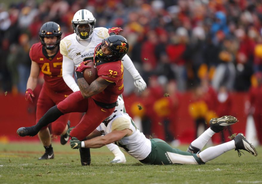 Iowa State running back David Montgomery, front left, runs the ball as he is tackled by Baylor linebacker Clay Johnston, right, during the first half of an NCAA college football game, Saturday, Nov. 10, 2018, in Ames. (AP Photo/Matthew Putney)