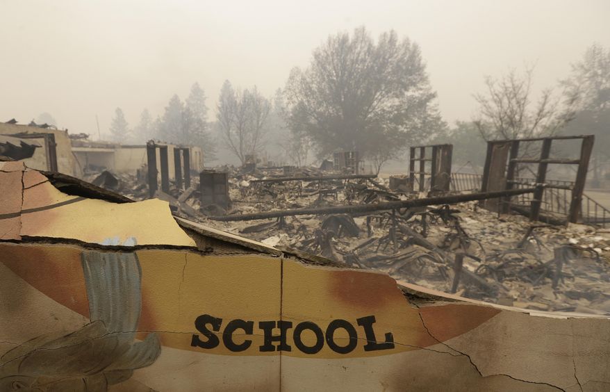 The burned remains of the Paradise Elementary school is seen Friday, Nov. 9, 2018, in Paradise, Calif. Blocks and blocks of homes and businesses in the Northern California town have been destroyed by a wildfire. Parts of the town of Paradise were still on fire on Friday. (AP Photo/Rich Pedroncelli)