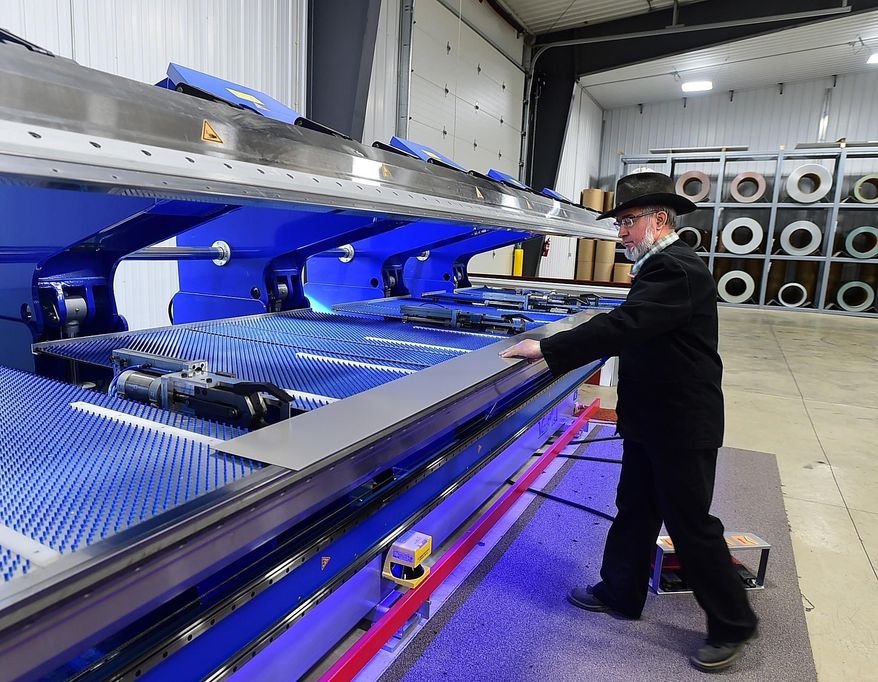 Dan Kleinsasser, of the Golden Valley Hutterite Colony near Ryegate, Mont. bends a steel roof snow dam at Valley Steel, LLC. The new venture builds custom steel siding and roofing products. (Larry Mayer/Billings Gazette via AP)