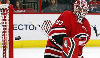 Carolina Hurricanes goaltender Scott Darling eyes the puck as it hits the post during the second period of the team&#x27;s NHL hockey game against the Detroit Red Wings, Saturday, Nov. 10, 2018, in Raleigh, N.C. (AP Photo/Karl B DeBlaker)