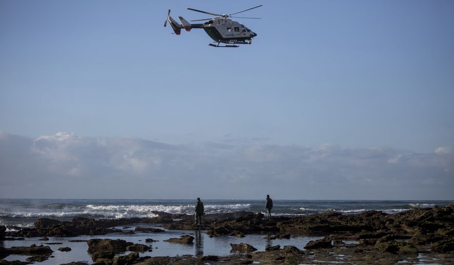 Members of Spanish Civil Guard with the help of a helicopter look for bodies of drowned migrants near the village of Canos de Meca in southern Spain, Tuesday, Nov. 6 2018. Spain&#39;s maritime rescue service says at least 17 people have died trying to reach Spanish territory in boats departing from North Africa but rescued 80 people Monday from two boats and recovered the bodies of 13 dead migrants in the Alboran Sea, part of the western Mediterranean route into Europe. In a separate incident, the Spanish Civil Guard says it found four bodies of migrants and 22 survivors, all men from northern Africa, after their wooden dinghy hit a reef. (AP Photo/Javier Fergo)