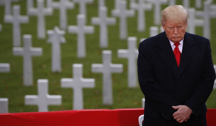 President Donald Trump stands in front of headstones during an American Commemoration Ceremony, Sunday Nov. 11, 2018, at Suresnes American Cemetery near Paris. Trump is attending centennial commemorations in Paris this weekend to mark the Armistice that ended World War I. (AP Photo/Jacquelyn Martin)