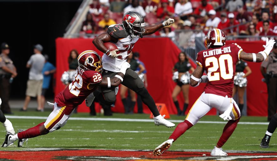 Tampa Bay Buccaneers running back Peyton Barber (25) is stopped by Washington Redskins defensive back Deshazor Everett (22) as free safety Ha Ha Clinton-Dix (20) close in during the first half of an NFL football game Sunday, Nov. 11, 2018, in Tampa, Fla. (AP Photo/Mark LoMoglio)