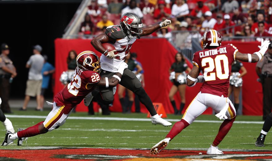 Tampa Bay Buccaneers running back Peyton Barber (25) is stopped by Washington Redskins defensive back Deshazor Everett (22) as free safety Ha Ha Clinton-Dix (20) close in during the first half of an NFL football game Sunday, Nov. 11, 2018, in Tampa, Fla. (AP Photo/Mark LoMoglio)