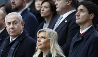 Israeli Prime Minister Benjamin Netanyahu, left, and his wife Sara, with Canadian Prime Minister Justin Trudeau, right, attend ceremonies at the Arc de Triomphe Sunday, Nov. 11, 2018 in Paris. Over 60 heads of state and government were taking part in a solemn ceremony at the Tomb of the Unknown Soldier, the mute and powerful symbol of sacrifice to the millions who died from 1914-18. (AP Photo/Francois Mori, Pool)