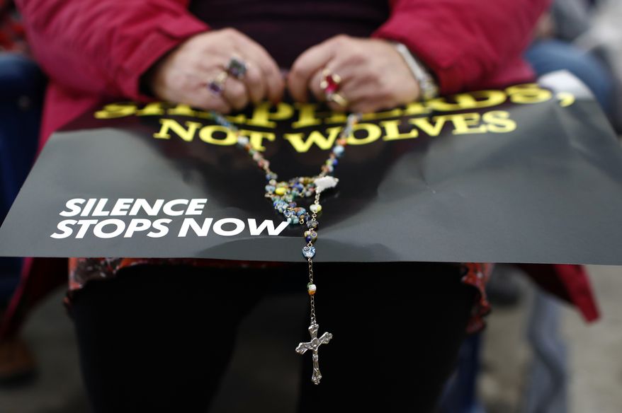 A woman prays the rosary at a rally organized by a coalition of conservative Catholic groups near the United States Conference of Catholic Bishops' annual fall meeting, Tuesday, Nov. 13, 2018, in Baltimore. (AP Photo/Patrick Semansky)