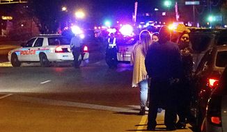 In this Nov. 12, 2018 photo, Albuquerque Police officers block off a street following an active shooter situation which wounded multiple people at a food distribution warehouse in Albuquerque, N.M. (Adolphe Pierre-Louis/The Albuquerque Journal via AP)