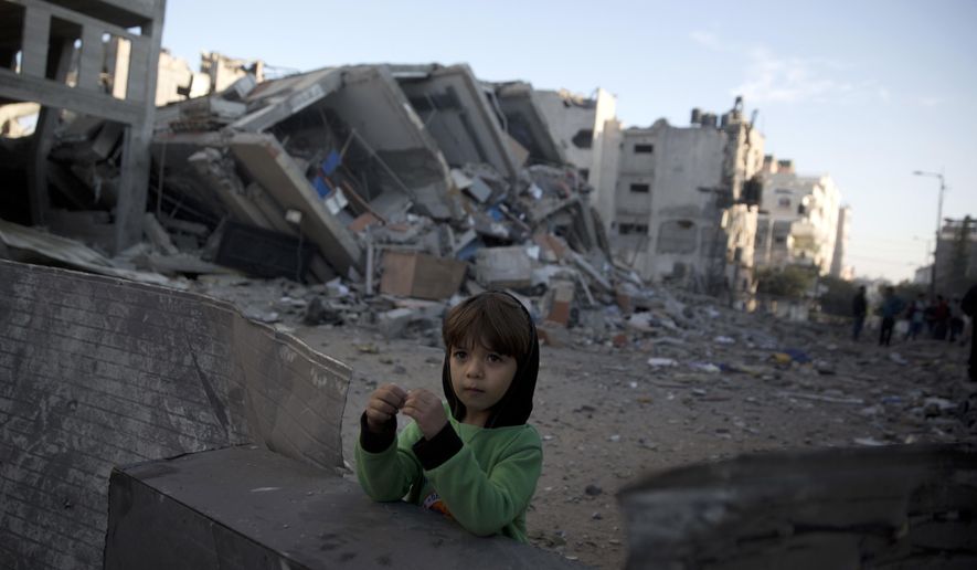A Palestinian boy stands next to the rubble of Hamas' Al-Aqsa TV station building which was hit by Israeli airstrikes on Monday, in Gaza City, Tuesday, Nov. 13, 2018. (AP Photo/Khalil Hamra)