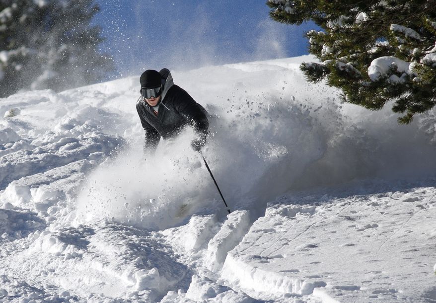 A skier makes a turn in fresh snow on Breckenridge Ski Resort's opening day Wednesday, Nov. 7, 2018, in Breckenridge, Colo. The resort opened early after receiving more than 5 feet of snow already this season. (Hugh Carey/Summit Daily News via AP)